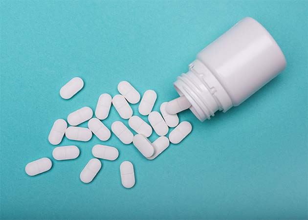 Pills spilled on teal background